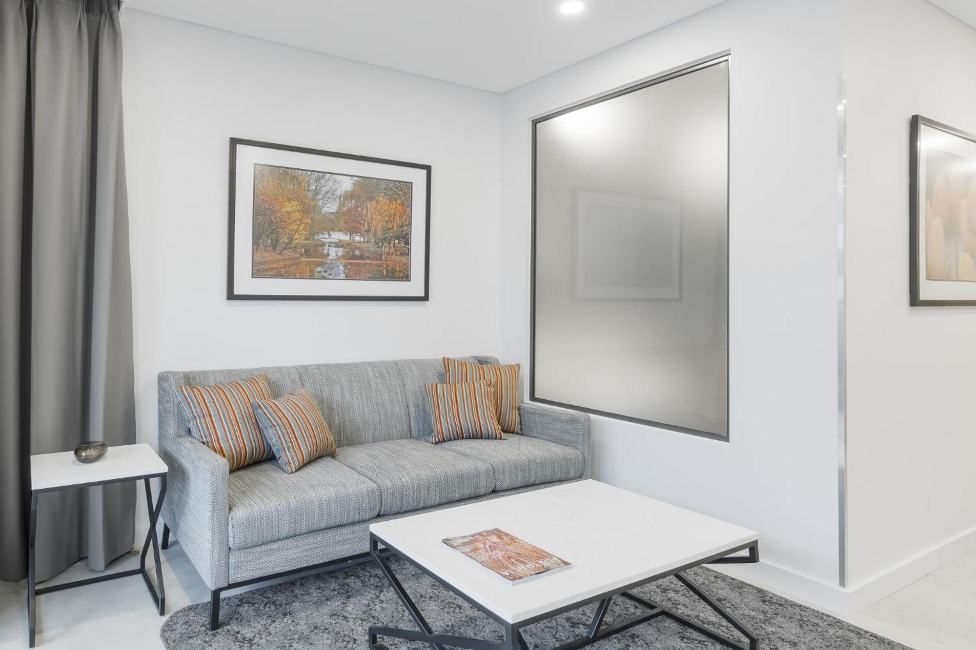Meriton Suites Canberra Exterior photo A living room with a sofa